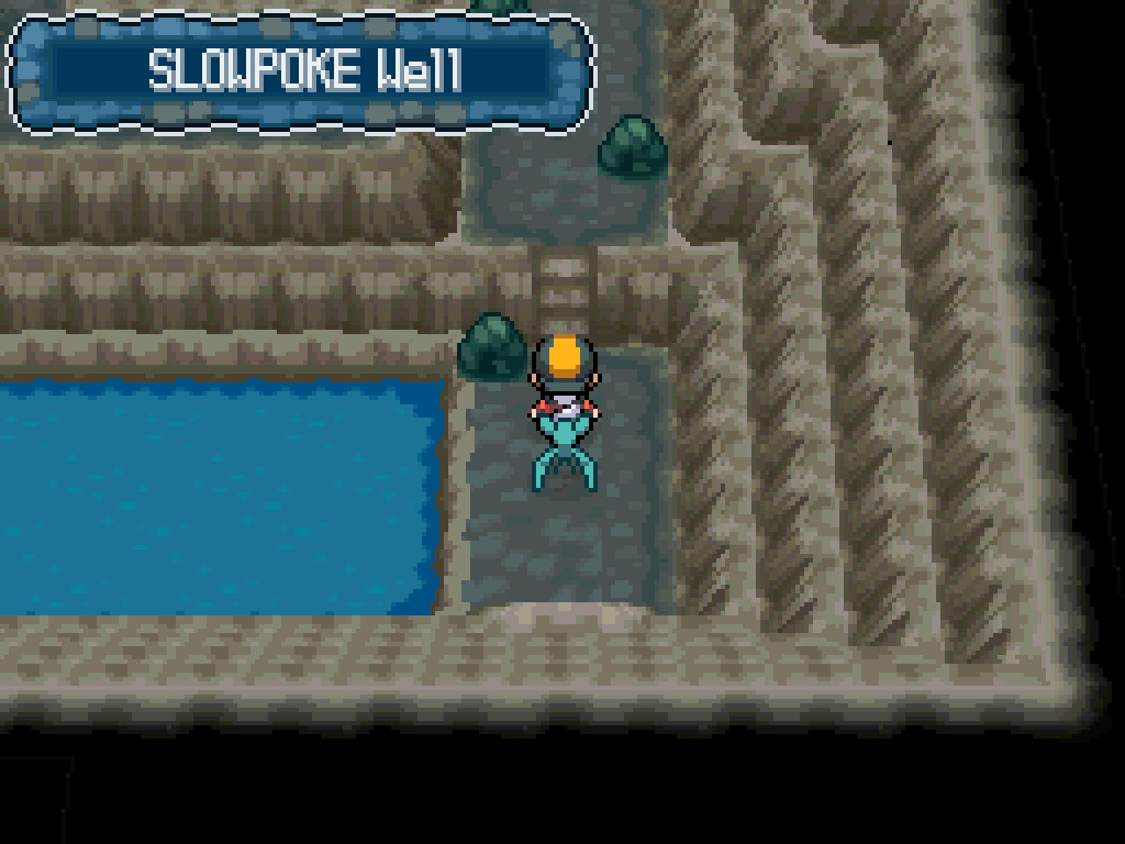 Stepping into the Slowpoke Well cave.  Unworked stone walls, uneven ground, a large pool of water.