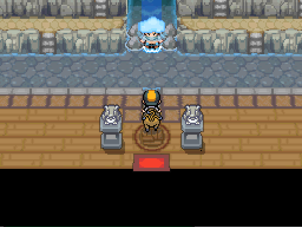Stepping into the gym. Stone terraces rise up towards the back of the building. The gym leader, Chuck, sits under a waterfall that falls between the terraces.